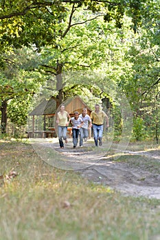 Portrait of happy family of four in autumn park running