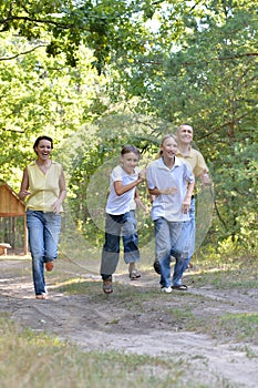 Portrait of happy family of four in autumn park running