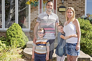 Portrait of happy family in front house