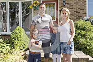 Portrait of happy family in front house