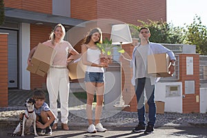 Portrait of happy family in front of new house