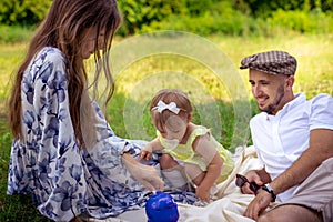 Portrait of Happy family having fun at the park. Parents with daughter relaxing outdoors