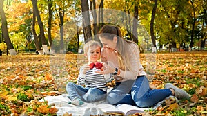 Portrait of happy family having picnic on blanket at autumn park