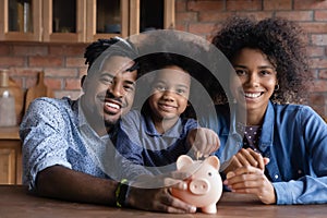 Portrait of happy family with kid saving money