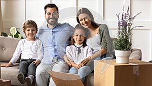 Portrait of happy family with kids relocating to new home