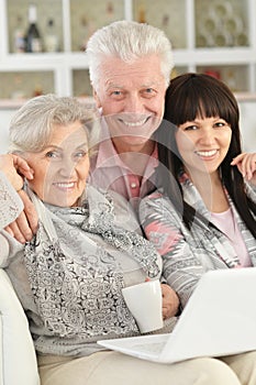 Portrait of happy family with laptop at home