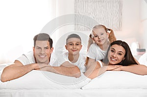 Portrait of happy family on large bed