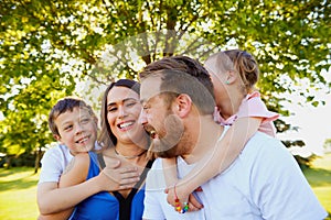 Portrait of happy family laughing in summer park