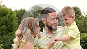 Portrait of a happy family with a little son in the Park in the summer, slow mo.