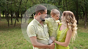 Portrait of a happy family with a little son in the Park in the summer. Slow mo.