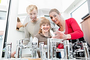 Portrait of a happy family looking for a new bathroom sink faucet