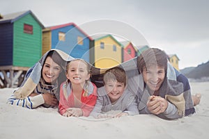 Portrait of happy family lying on sand