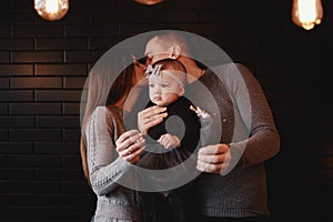Portrait of happy family, mom, dad and baby girl with sparklers and light. family in anticipation of Christmas. selective photo
