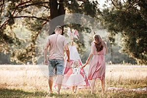 Portrait of happy family. Mom, dad and daughter walk in the park in nature. Young family spending time together on
