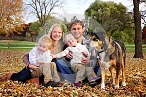 Portrait of a Happy Family of Mother Father and Two Kids and Their Dog on an Autumn Day