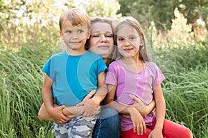 Portrait of a happy family, mother, son and daughter, in nature outdoor in summer.