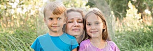 Portrait of a happy family, mother, son and daughter, in nature outdoor in summer. banner.