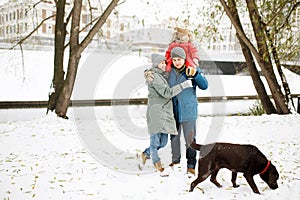 Portrait of happy family with one kid and dog in winter casual outfit posing outdoors