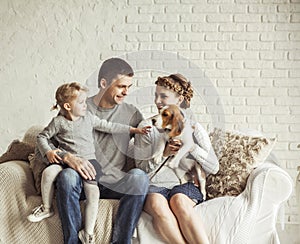 Portrait of a happy family and a pet sitting on a sofa