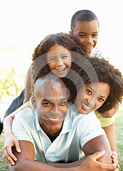 Retrato familia feliz acumula arriba en el parque 