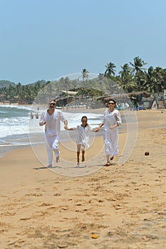 Portrait of happy family running on a beach