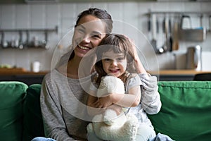 Portrait of happy family single mother and kid daughter embracin
