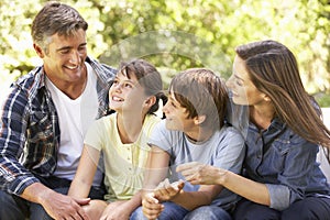 Portrait Of Happy Family Sitting In Garden Together