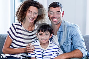 Portrait of happy family sitting together on sofa