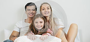 Portrait happy family spending time together on bed in bedroom. family and home concept.