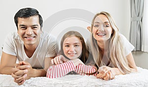 Portrait happy family spending time together on bed in bedroom. family and home concept.