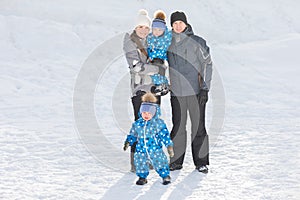 Portrait of happy family with twins in winter Park on a Sunny day