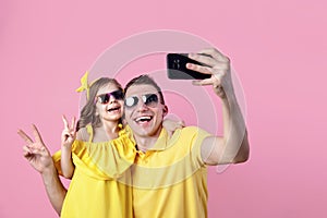 Portrait of happy family of two people. Daddy and little daughter doing selfie with smartphone. Horizontal color