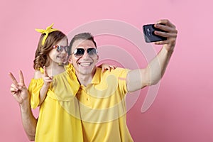 Portrait of happy family of two people. Daddy and little daughter doing selfie with smartphone. Horizontal color