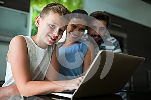 Portrait of happy family using laptop in the living room