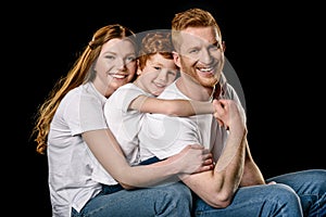 Portrait of happy family in white t-shirts hugging each other