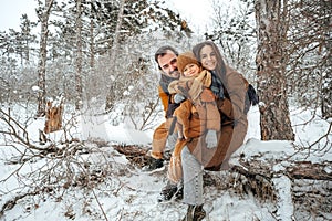 Portrait of happy family in winter clothes in forest