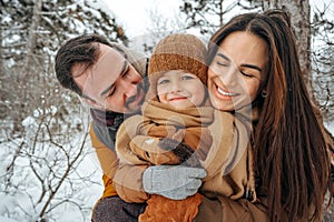 Portrait of happy family in winter clothes in forest