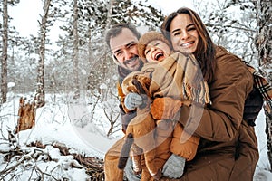 Portrait of happy family in winter clothes in forest