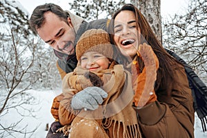 Portrait of happy family in winter clothes in forest