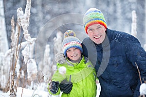 Portrait of a happy family in winter park. Father, son and little daughter laughing