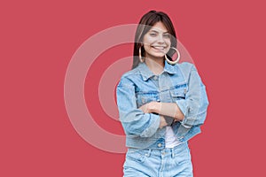 Portrait of happy fancy beautiful brunette young woman with makeup in denim casual style standing with crossed hands and looking