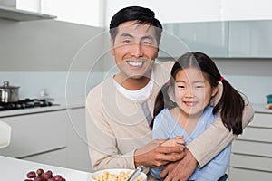 Portrait of a happy father with daughter in kitchen