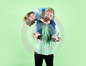 Portrait of happy father giving son piggyback ride on his shoulders. Generations family.