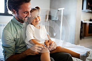 Portrait of happy father and his adorable little daughter spending good time together