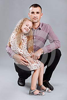 Portrait of a happy father holding his little daughter on his lab isolated over gray background