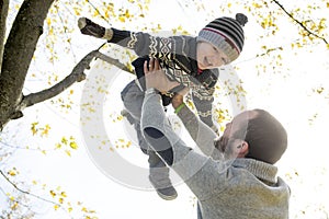 Portrait of happy father with son in autumn park