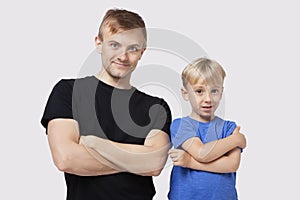 Portrait of happy father and son in casuals with arms crossed over white background photo