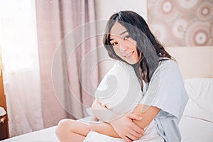 Beautiful Positive woman sitting in bed in morning