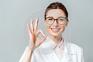 Portrait of a happy female doctor showing the OK sign