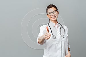 Portrait of a happy female doctor with a stethoscope showing the OK sign